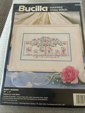 Bucilla cross-stitch kit with blue border and pink accents
